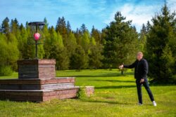 Metsajõe puhkemaja disc-golfirajal mängib mees disc-golfi